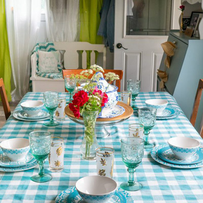 A fully set table with a blue checker pattern table cloth.