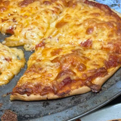 Freshly cooked cheese pizza sitting on a pan.